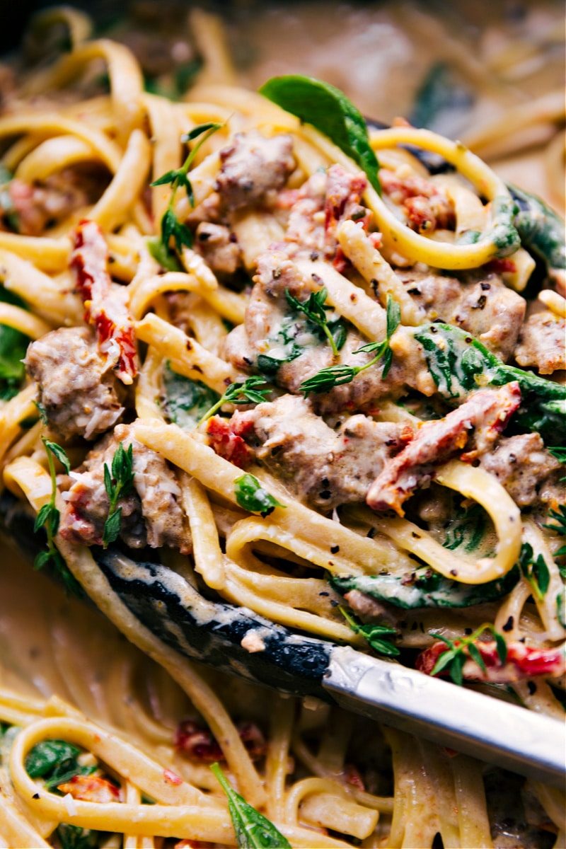 Creamy pasta with fettuccine, sausage, sun-dried tomatoes, spinach, and sauce.