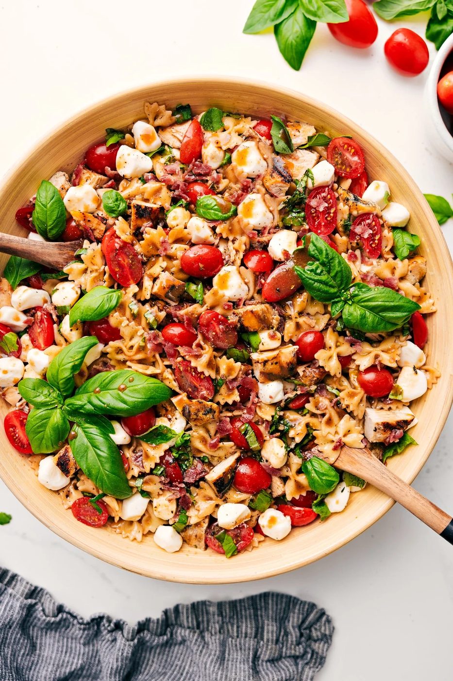 Italian recipes Caprese pasta salad with chicken, bacon, tomatoes, mozzarella, basil, and balsamic.