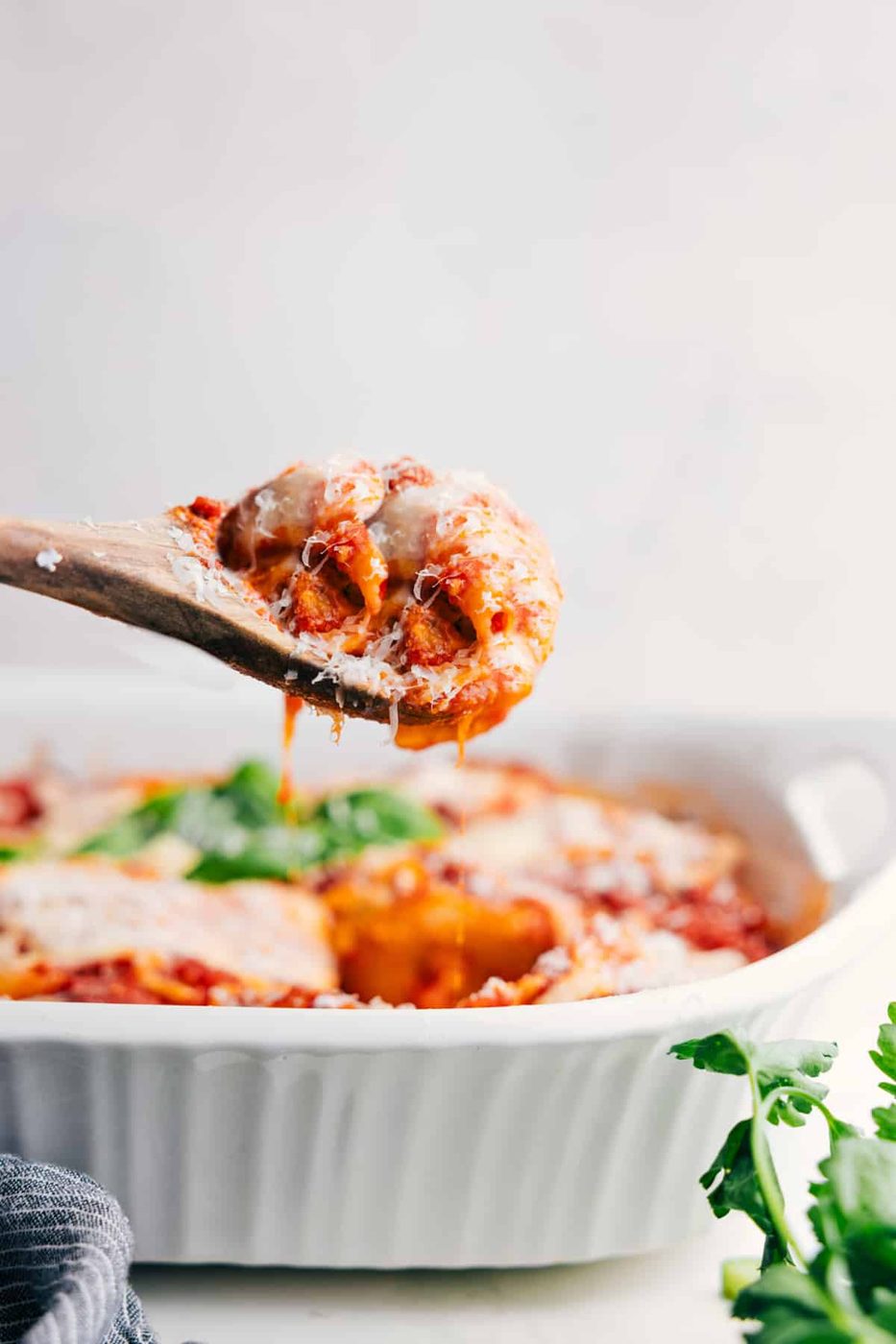 A big scoop of this cheesy dish being lifted from the pan and ready to serve.