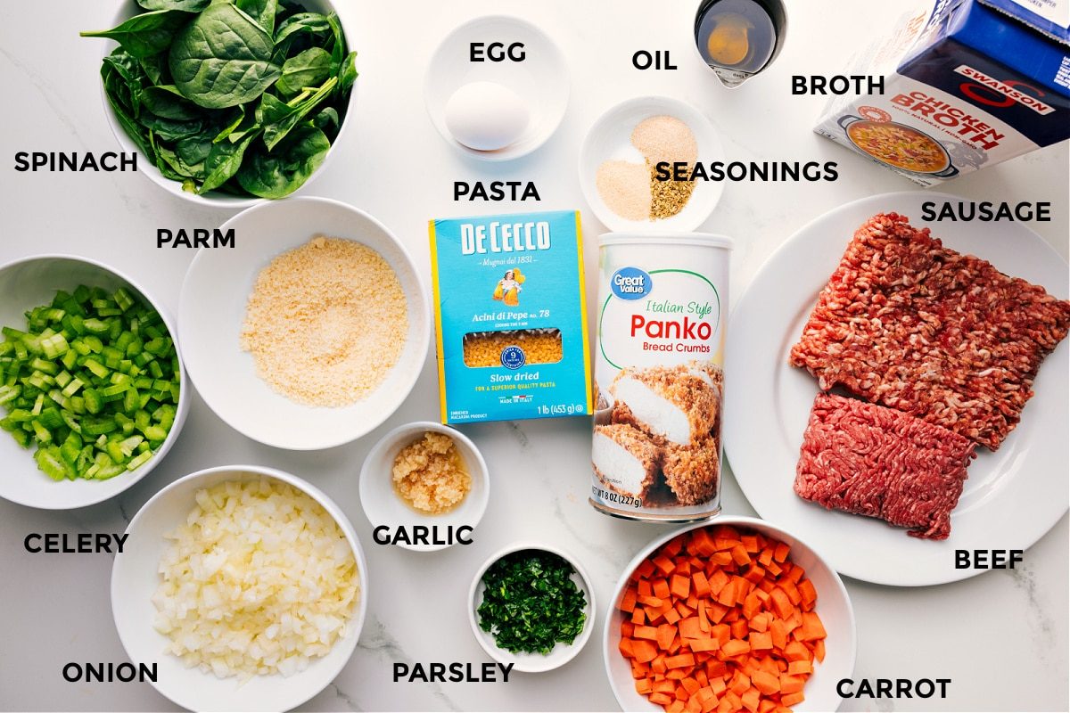 Ingredients prepped for straightforward assembly including spinach, celery, onion, Parmesan, garlic, parsley, carrots, panko, beef, sausage, broth, seasonings, oil, egg, and pasta.
