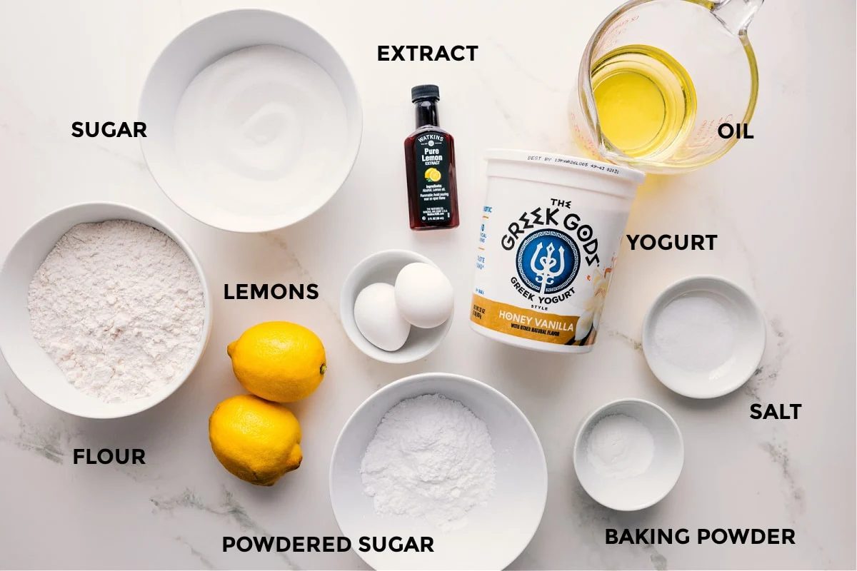 All the ingredients in this recipe prepped out for straightforward assembly including the flour, sugar, extract, lemons, powdered sugar, baking powder, salt, yogurt, and oil.
