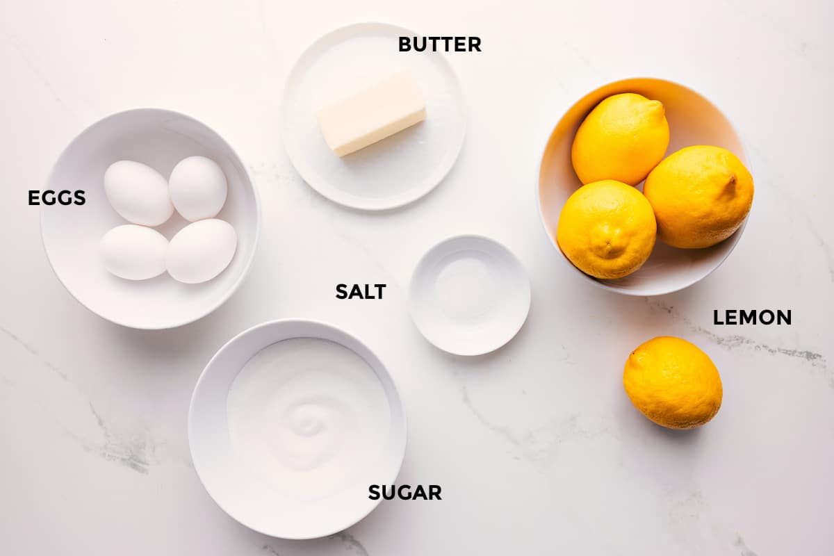All the ingredients in this recipe prepped out for straightforward assembly including the eggs, butter, sugar, salt, and lemons.