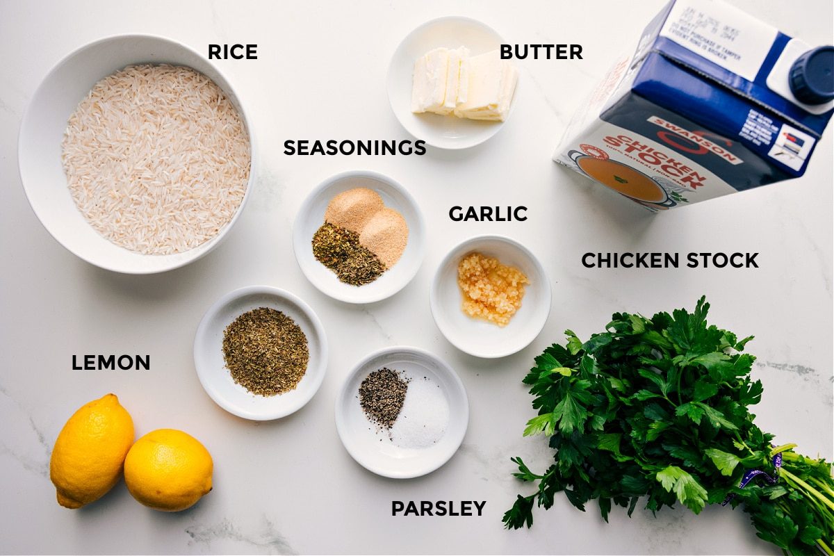 All the ingredients in this recipe prepped out for straightforward assembly including the rice, seasonings, lemon, garlic, butter, parsley, and chicken stock.