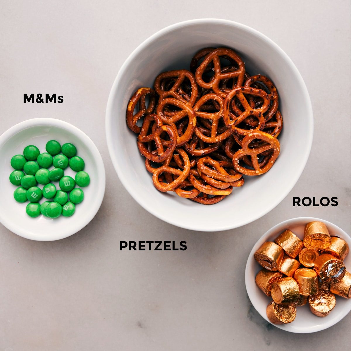 The 3 simple ingredients—M&Ms, pretzels, and Rolos—are prepped for straightforward assembly.