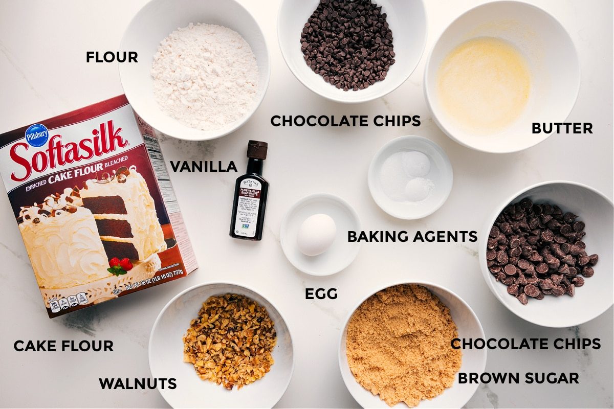 All the ingredients in this recipe prepped out for straightforward assembly including cake flour, flour, walnuts, vanilla, egg, brown sugar, chocolate chips, butter, baking agents, and chocolate chips.
