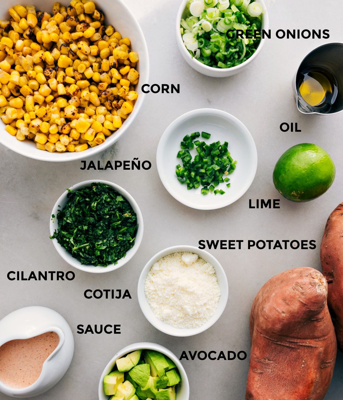 This recipe has everything prepped for straightforward assembly—corn, green onions, oil, lime, jalapeño, veggies, cotija, and sauce.