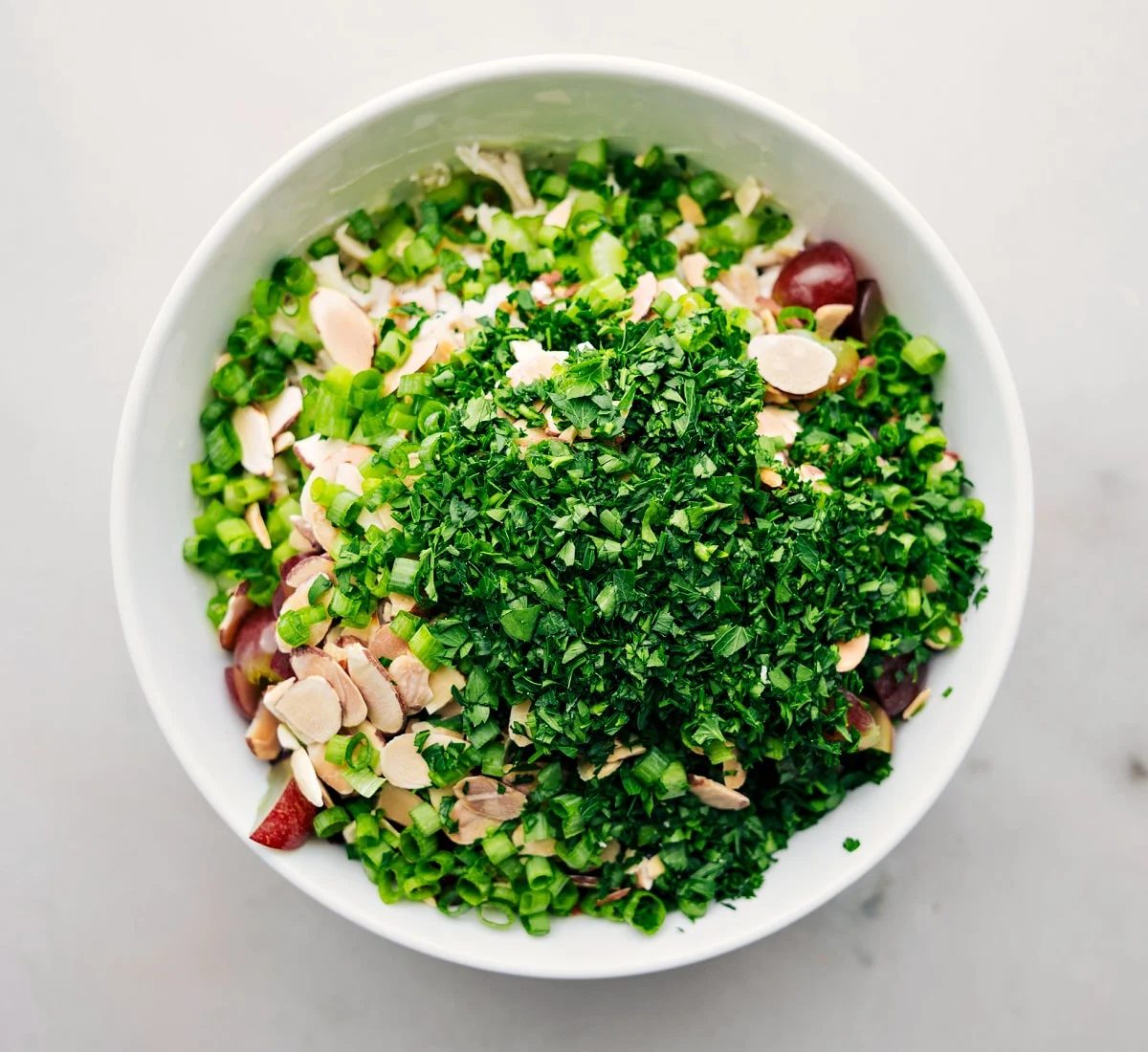 All the ingredients being added to a bowl to be tossed together.
