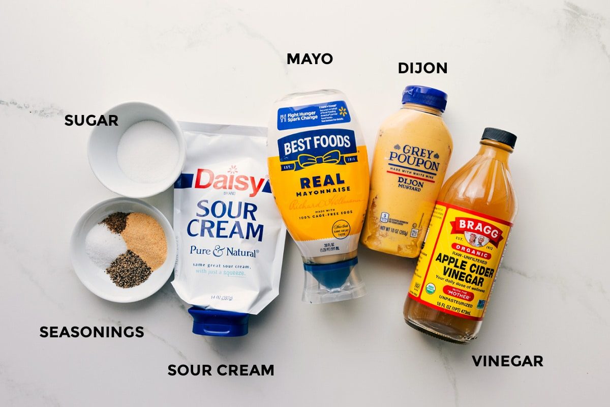All the ingredients for the dressing in this macaroni salad recipe prepped out for straightforward assembly including the mayo, dijon, apple cider vinegar, seasonings, and sugar.