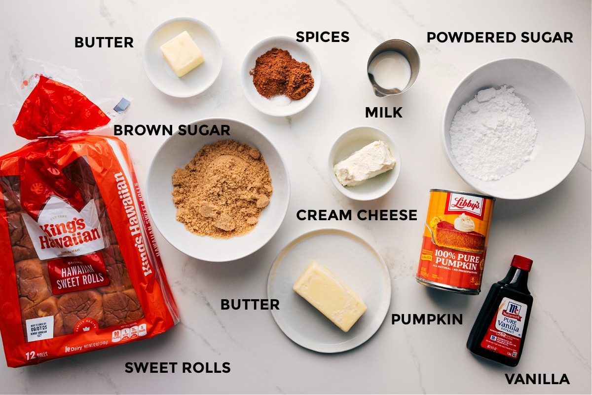 All the ingredients in this recipe prepped out for straightforward assembly: rolls, butter, brown sugar, spices, cream cheese, milk, powdered sugar, pumpkin, and vanilla.