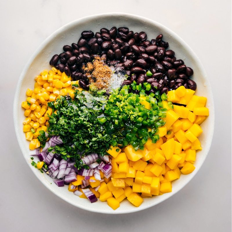 Mango Black Bean Salsa ingredients all added to a bowl to be mixed together.