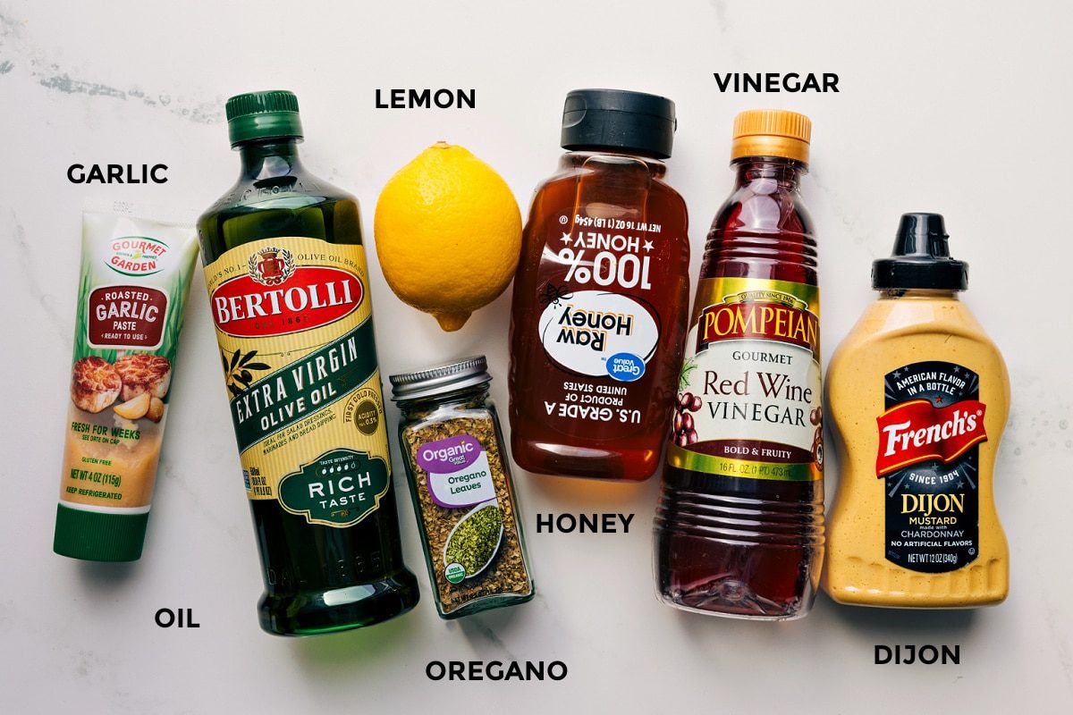 All the dressing ingredients prepped for straightforward assembly, including garlic, olive oil, lemon, oregano, honey, vinegar, and Dijon.