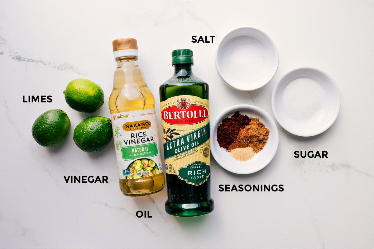 The dressing ingredients prepped for Mexican Pasta Salad—limes, rice vinegar, olive oil, seasonings, sugar, and salt.