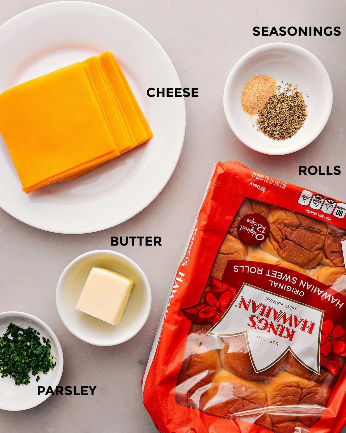 All the ingredients in this recipe are prepped for straightforward assembly: rolls, butter, cheese, parsley, and seasonings.