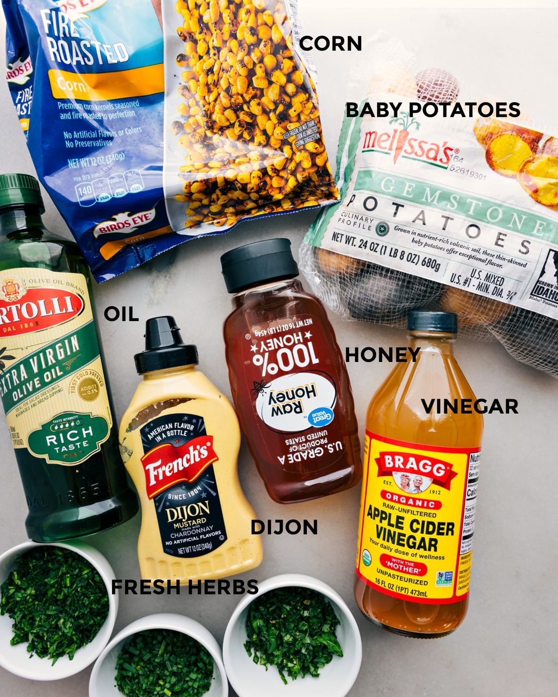 All the ingredients in this recipe including the corn, veggies, oil, dijon, honey, and vinegar prepped out for straightforward assembly.