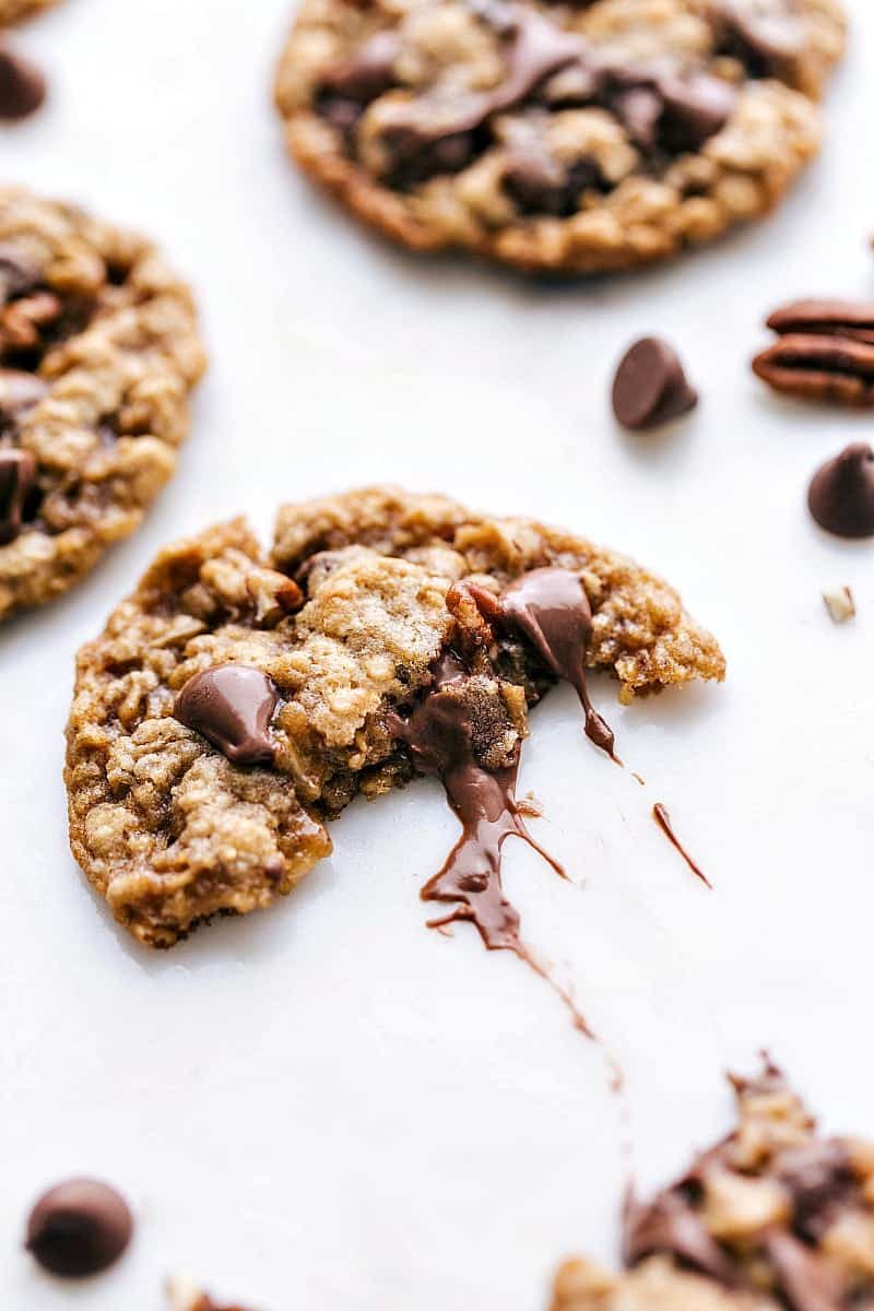 Oatmeal chocolate chip pecan cookies split in half to reveal the gooey chocolate center.