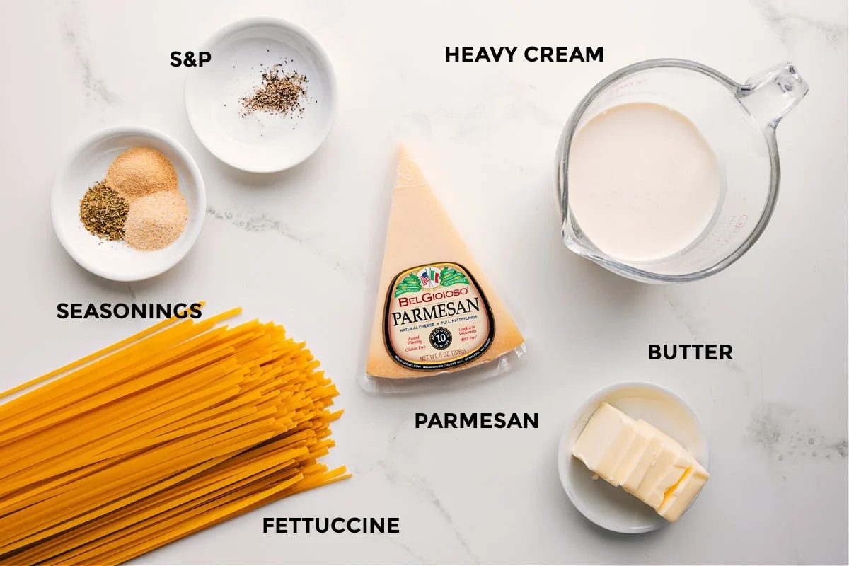 All the ingredients in this recipe prepped out for straightforward assembly including the seasonings, fettuccine, parmesan, heavy cream, and butter.