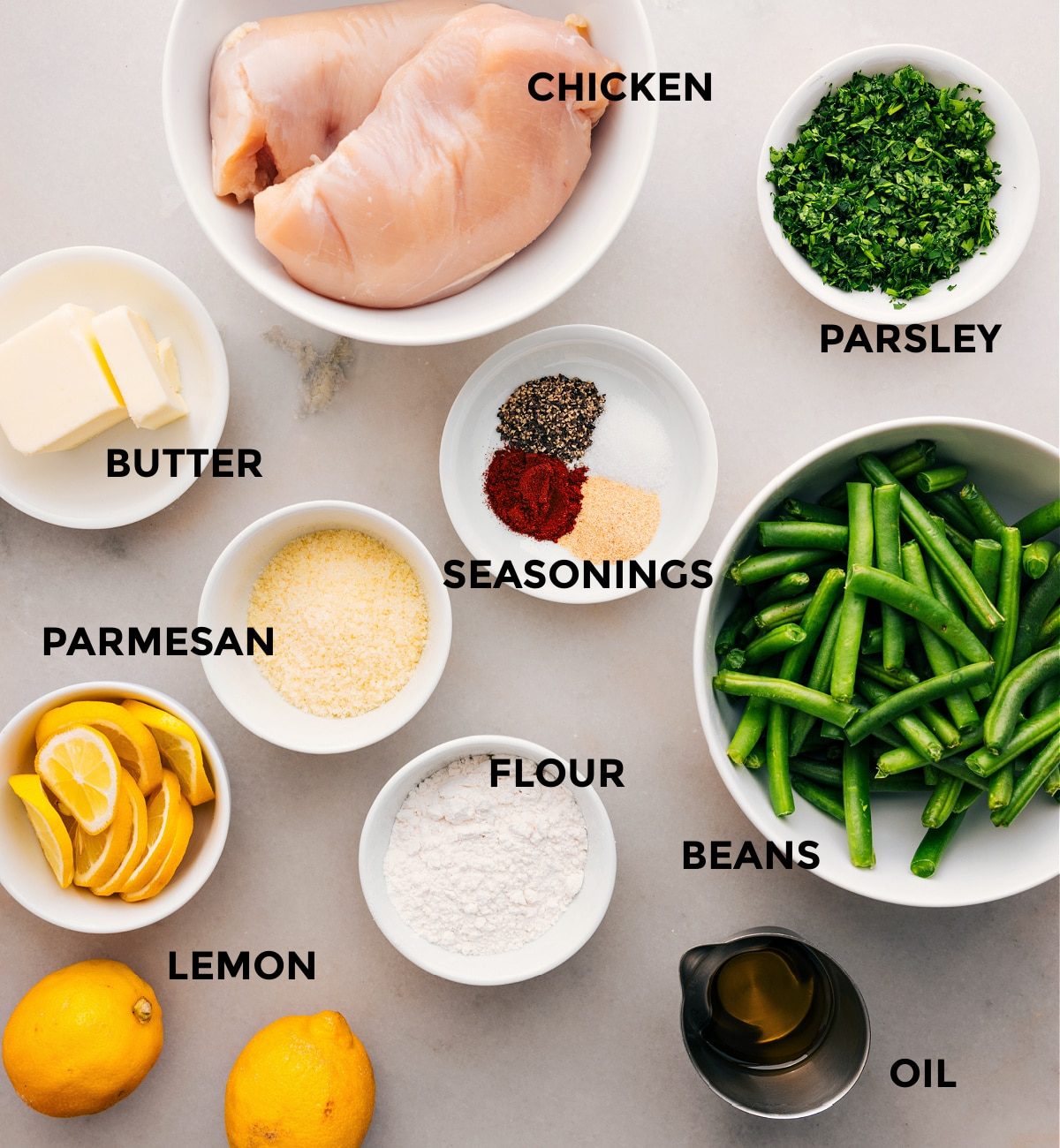 Prep all the ingredients for this recipe, including the meat, beans, parsley, seasonings, butter, flour, cheese, and lemons, for straightforward assembly.