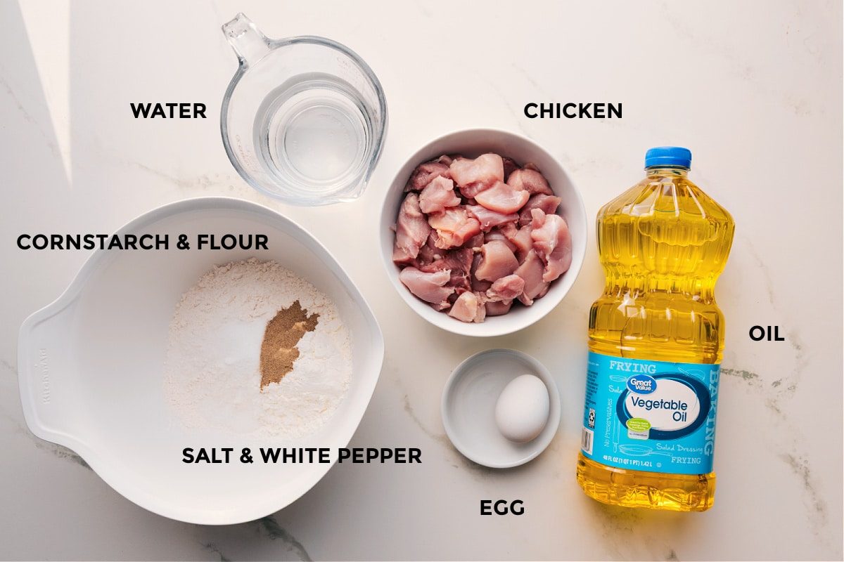 All the ingredients in this Panda Express orange chicken recipe prepped out for straightforward assembly including the water, cornstarch, salt, white pepper, chicken, egg, and oil.