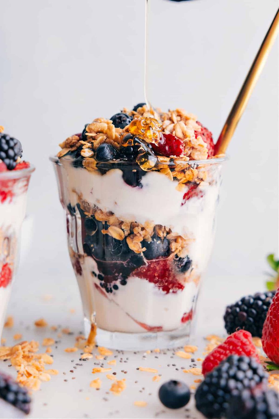 Yogurt parfait with a drizzle of honey being added on top, enhancing the sweetness and flavor.