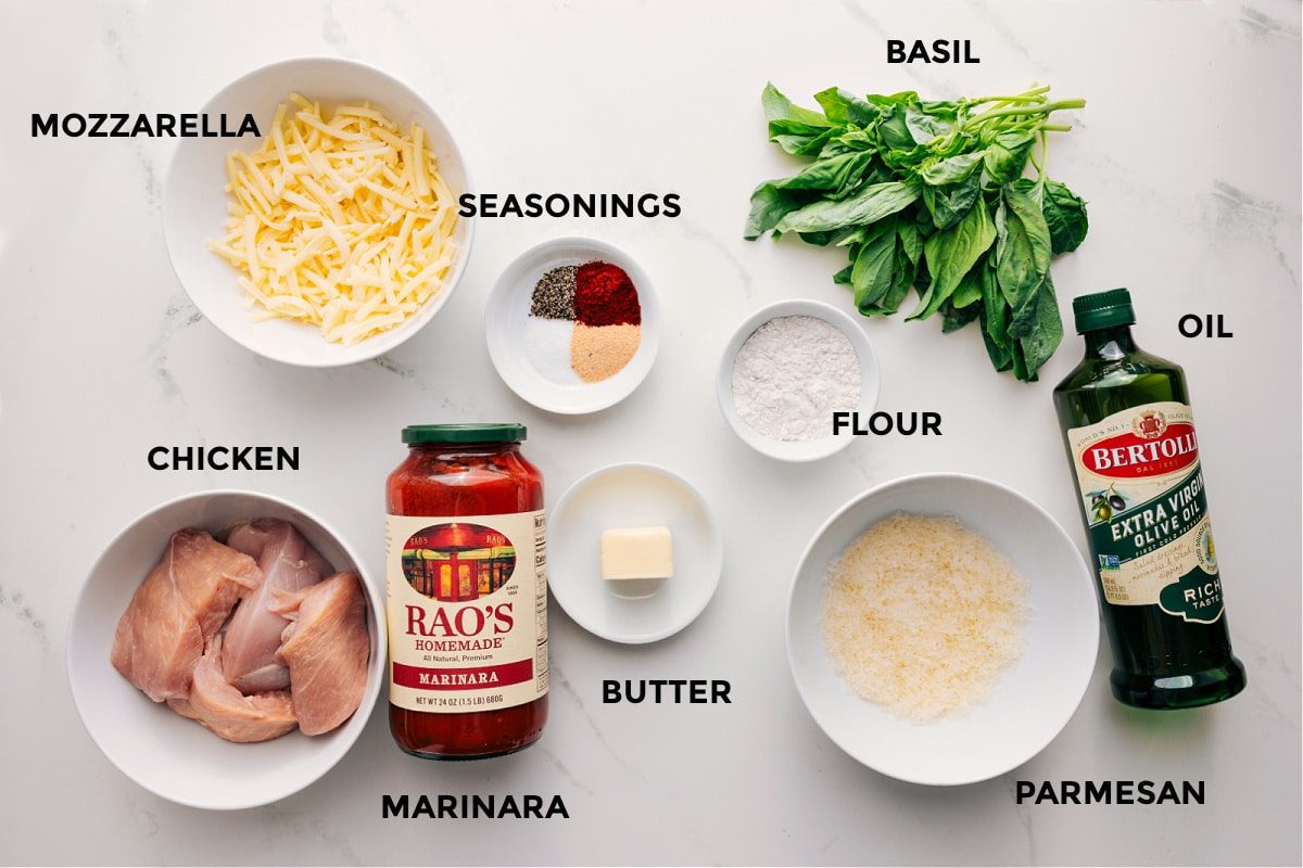 Ingredients in this recipe prepped out for straightforward assembly including the mozzarella, chicken, seasoning, marinara, butter, flour, parmesan, basil, and oil.
