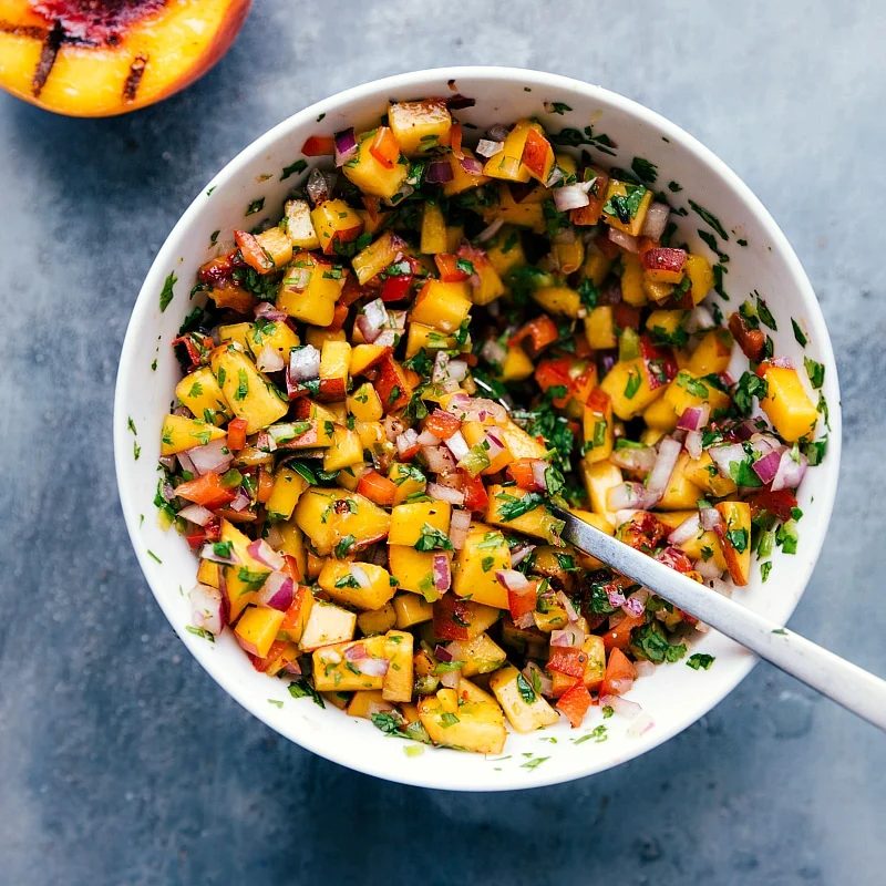 Fresh and satisfying chicken with peach salsa, with all ingredients mixed together in a bowl.