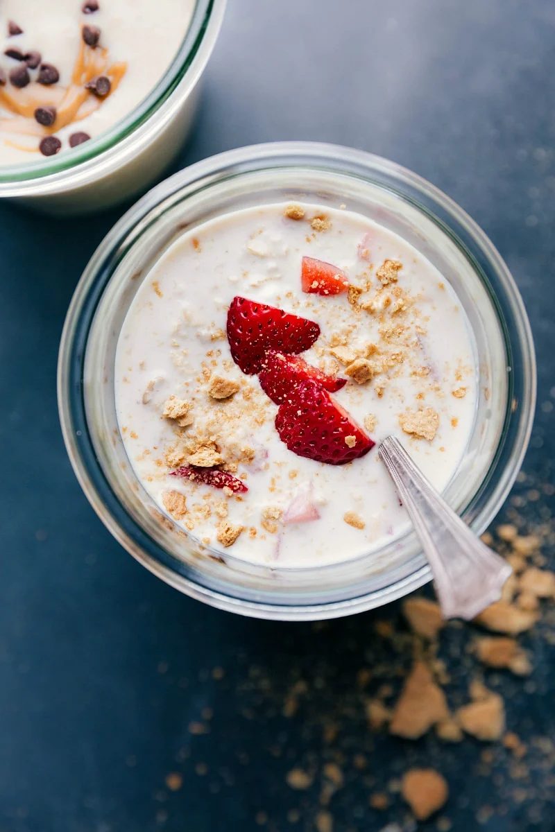 Finished strawberry cheesecake overnight oats, topped with fresh strawberries, ready for a satisfying breakfast.