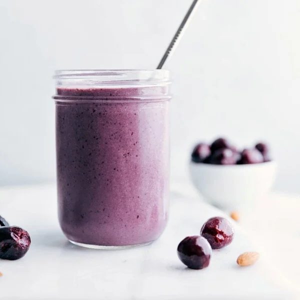 A satisfying cherry smoothie with a straw in it, showcasing a vibrant color and smooth texture.