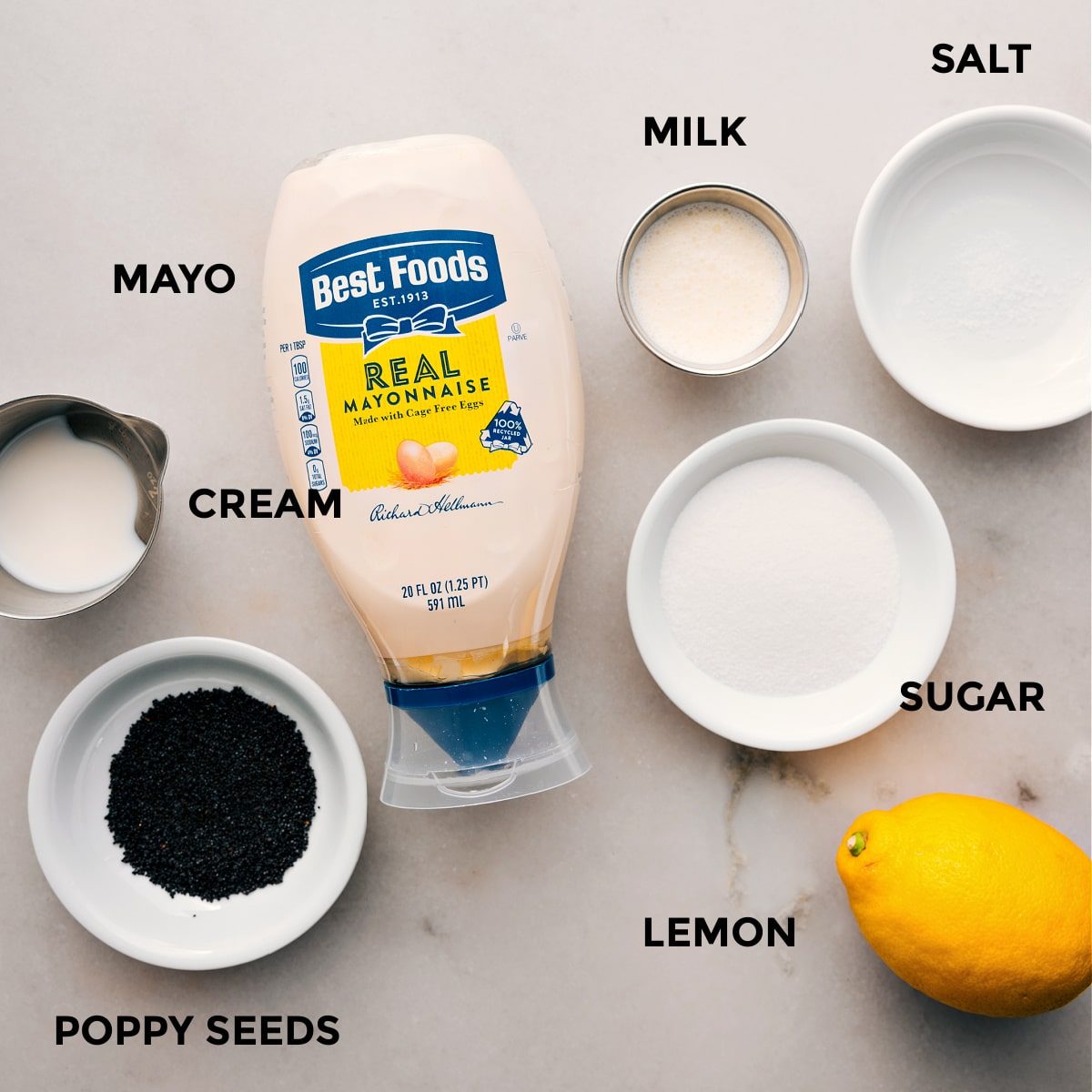 The dressing ingredients for this blackberry salad are prepped for straightforward assembly, including mayo, cream, sugar, lemon, milk, salt, and poppyseeds.
