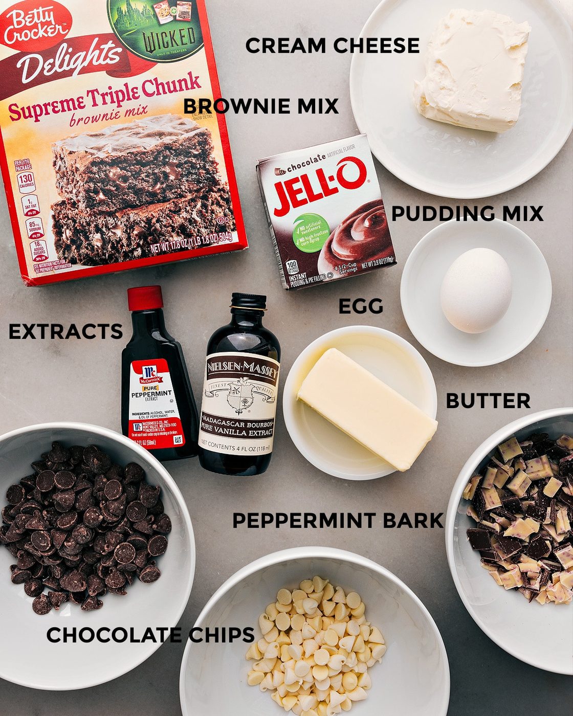 The ingredients for this recipe—brownie mix, pudding mix, cream cheese, egg, butter, extracts, and chocolate chips—are prepped and ready for straightforward assembly.