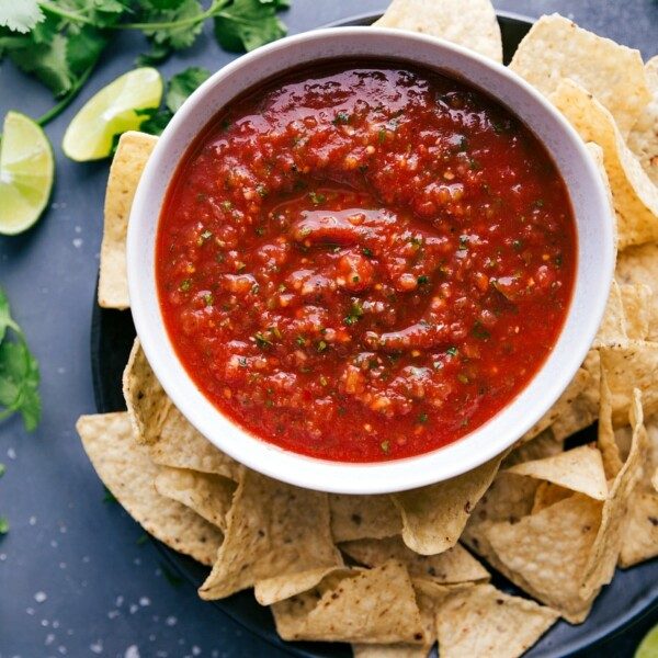 A big bowl of satisfying salsa, packed with vibrant flavors, paired with a pile of crispy chips ready for dipping.