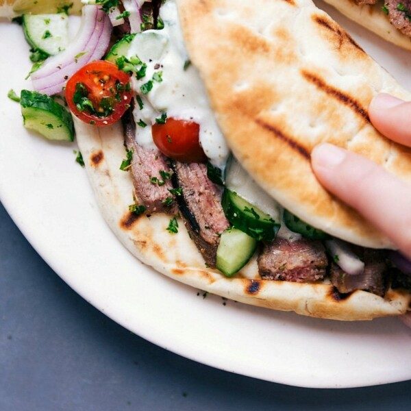 Steak gyros fully stuffed with succulent meat, fresh vegetables, and a satisfying sauce, ready to be eaten.