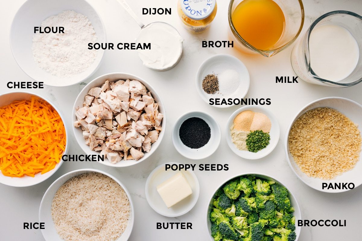 Ingredients for Poppy Seed Chicken Casserole prepped for assembly, including cheese, rice, chicken, broccoli, panko, and sauce ingredients.