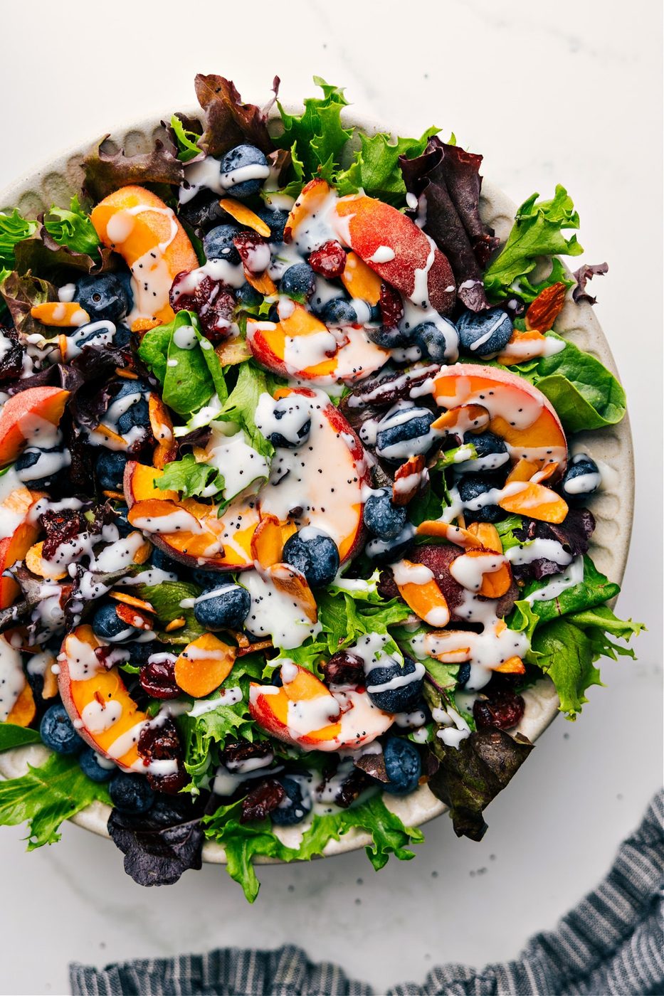Bowl of peach and blueberry salad drizzled with this poppyseed dressing recipe.