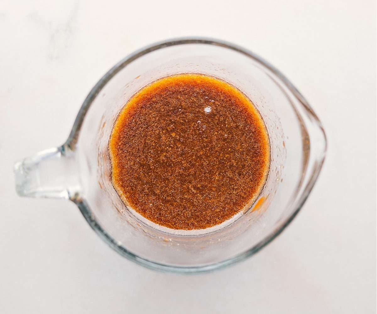 The sauce for this Pork Ramen Stir Fry Recipe being whisked together in a liquid measuring cup.