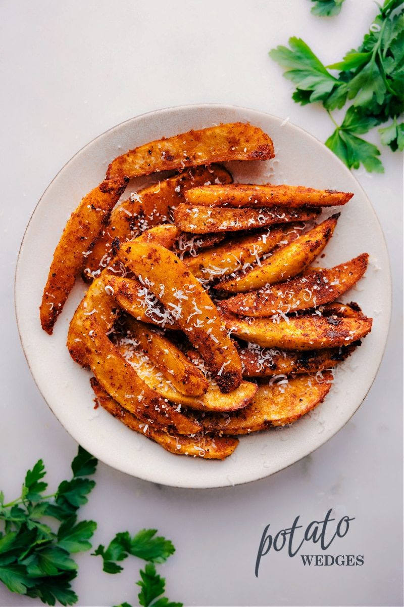 Crispy potato wedges served on a white plate.