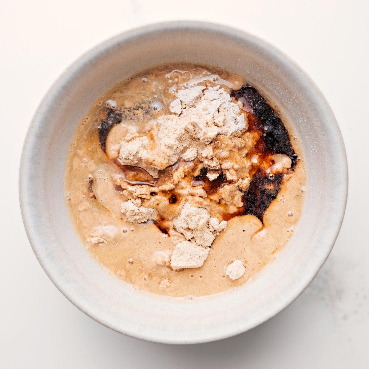 All the ingredients for protein cookie dough combined in a bowl to create the most satisfying high-protein treat.