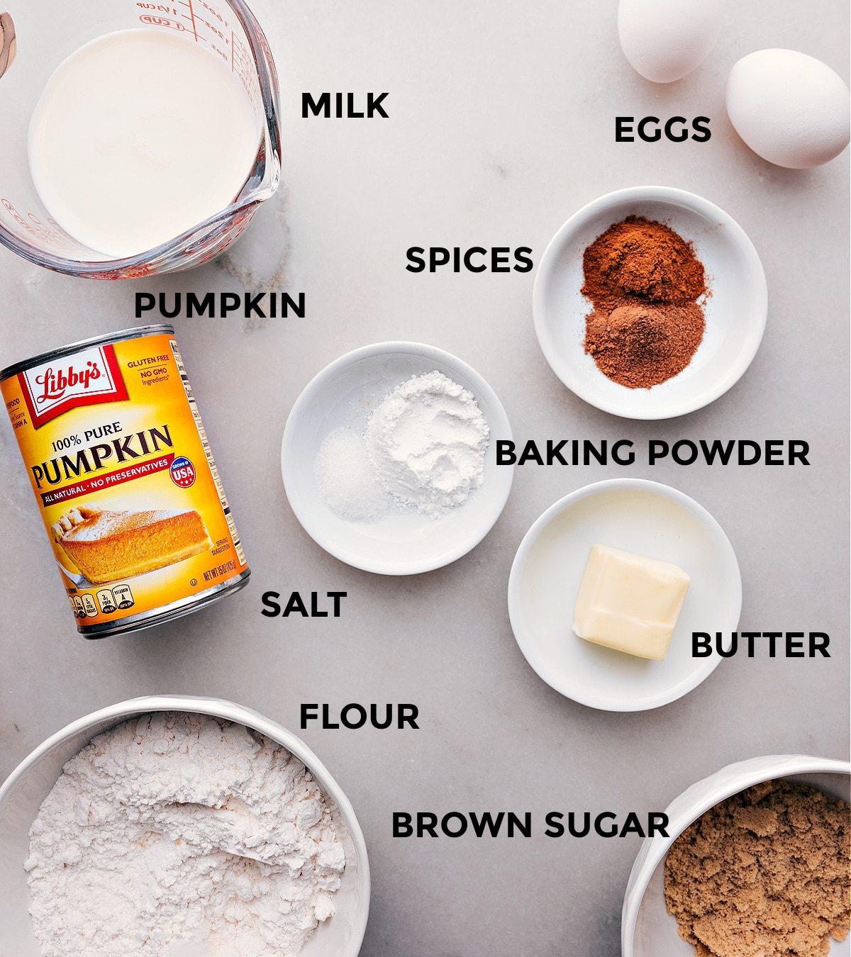All the ingredients in this recipe prepped out for straightforward assembly including the pumpkin, spices, eggs, baking powder, salt, butter, flour, and sugar.