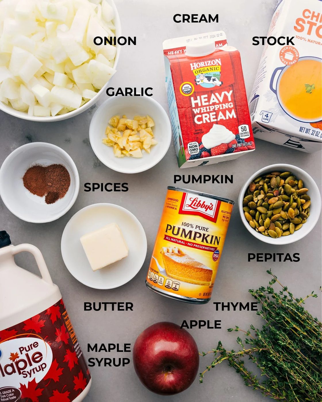 All the ingredients for this recipe are prepped and ready for straightforward assembly, including onion, heavy cream, stock, spices, garlic, canned pumpkin, and pepitas.
