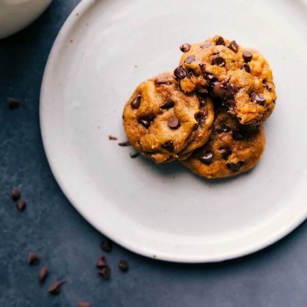 Soft pumpkin cookies on a plate with warm, melting chocolate chips, satisfying and ready to be eaten.