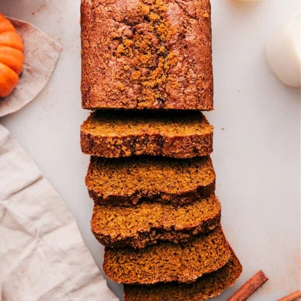 A loaf of the satisfying pumpkin bread, with half sliced into individual pieces, ready to enjoy.