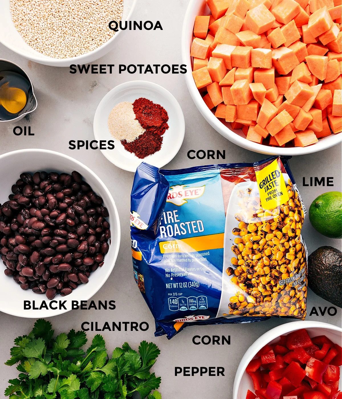 All the ingredients for this recipe prepped and ready for straightforward assembly, including beans, corn, grains, veggies, spices, lime, and oil.