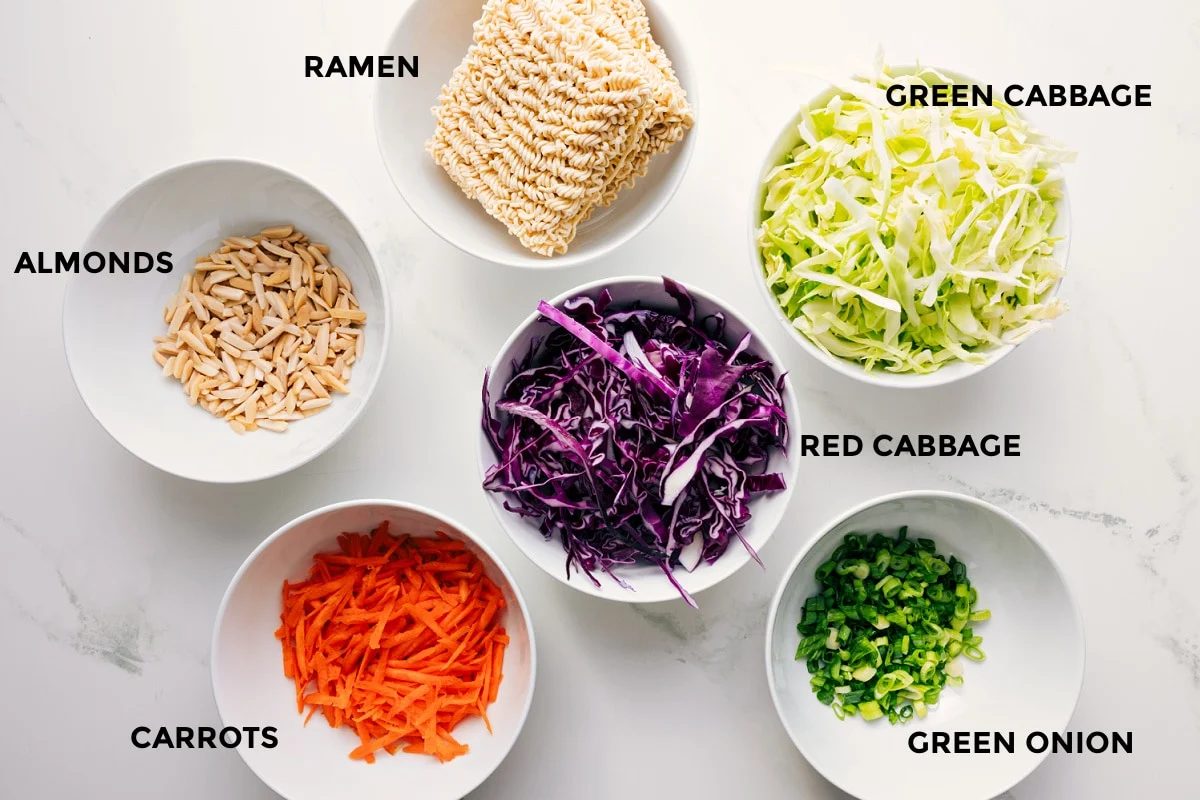 All the ingredients in this recipe prepped out for straightforward assembly including the almonds, carrots, cabbage, green onions, and ramen.