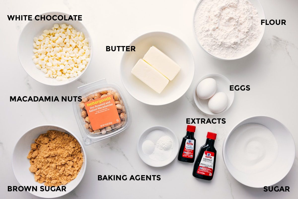 All the ingredients in this recipe prepped out for straightforward assembly including the white chocolate, macadamia nuts, brown sugar, butter, flour, eggs, extracts, sugar, and baking agents.