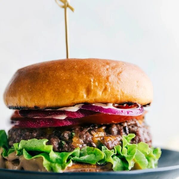 A mouthwatering burger created from this burger recipe, featuring a juicy patty sandwiched between soft buns, topped with a variety of satisfying toppings.