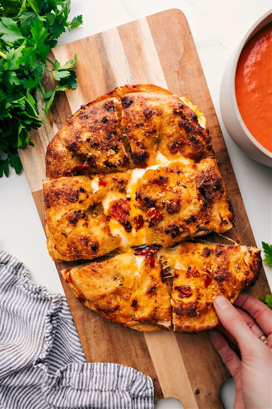 Focaccia grilled cheese with three melted cheeses, pesto, and sun-dried tomato Parmesan bread.