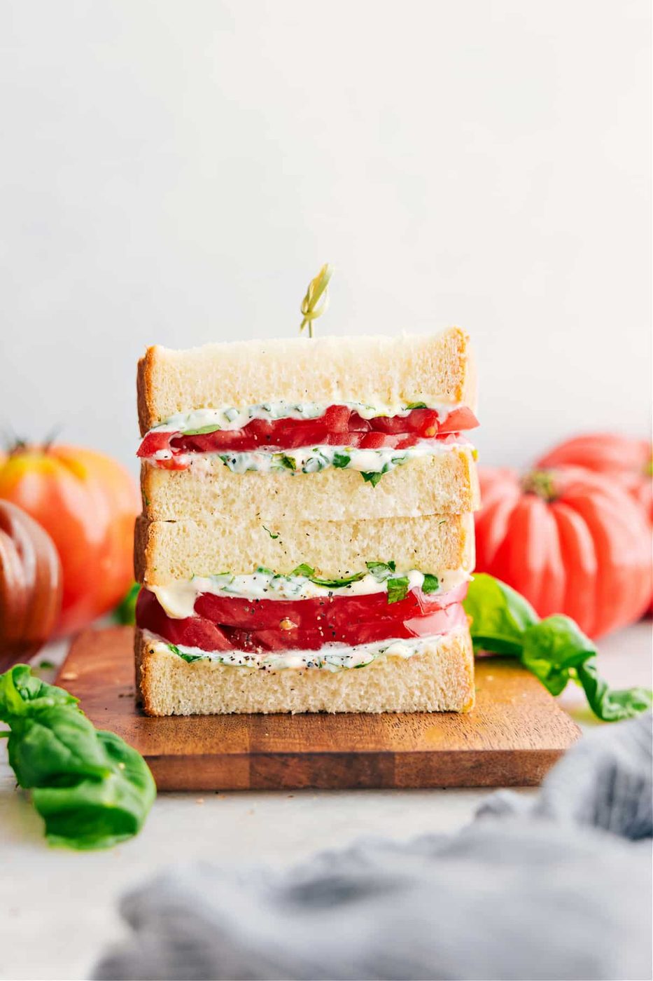 Tomato sandwich with thick tomatoes and basil mayo on soft white bread.