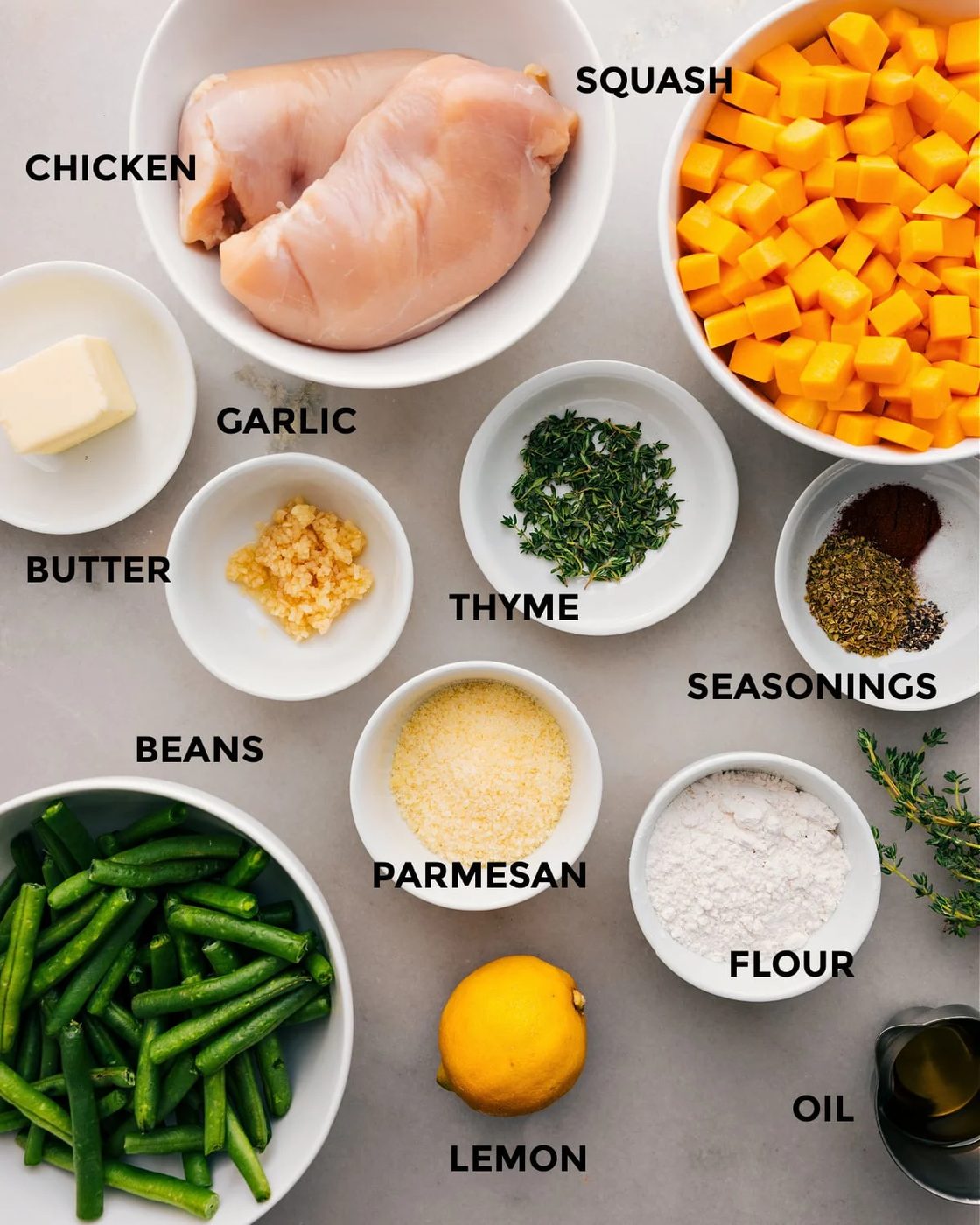 All the ingredients for this recipe are prepped and ready for straightforward assembly, including the meat, veggies, fresh herbs, butter, Parmesan, flour, seasonings, and lemon.
