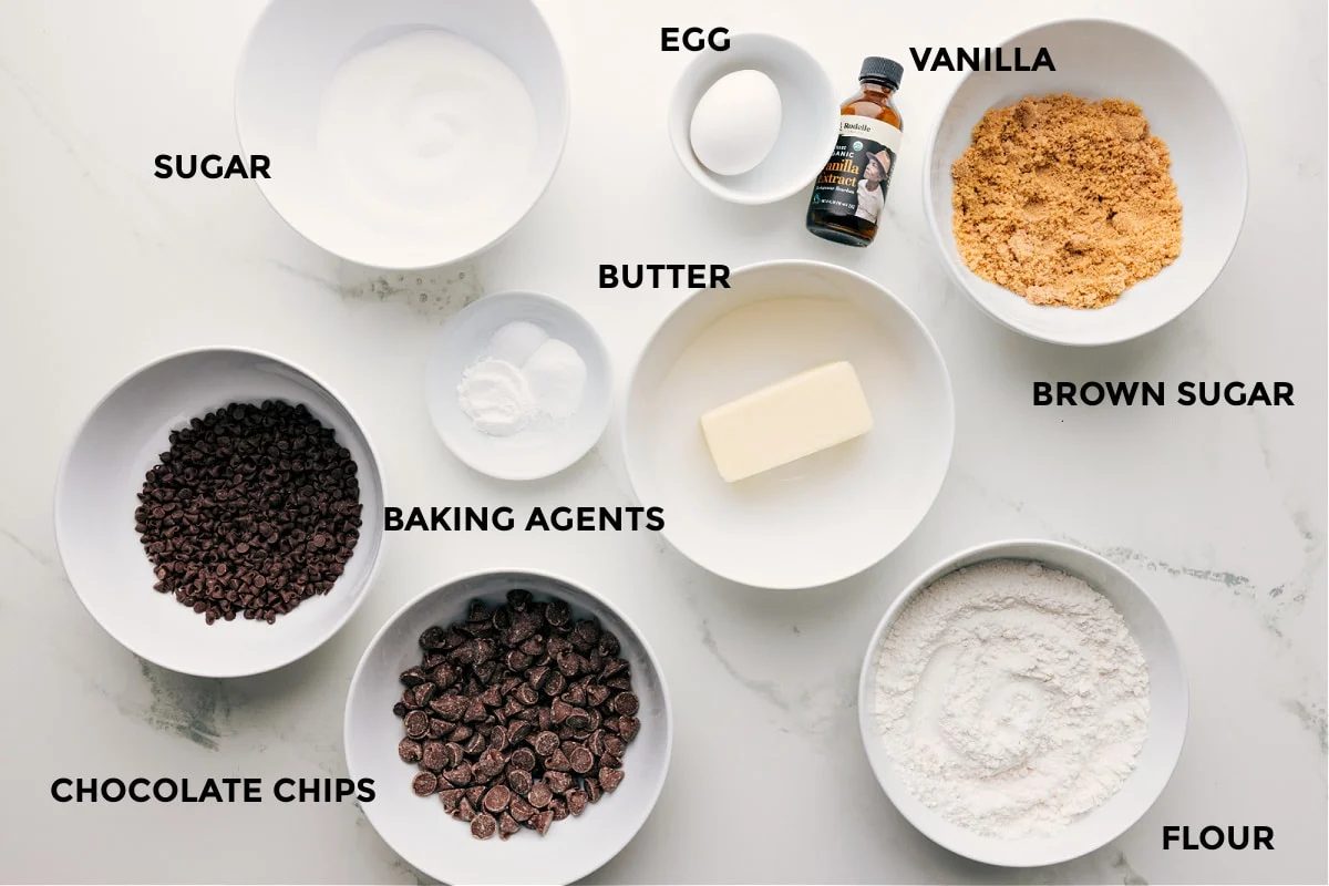All the ingredients in this recipe prepped out for straightforward assembly including the sugar, chocolate chips, baking agents, egg, butter, vanilla, brown sugar, and flour.