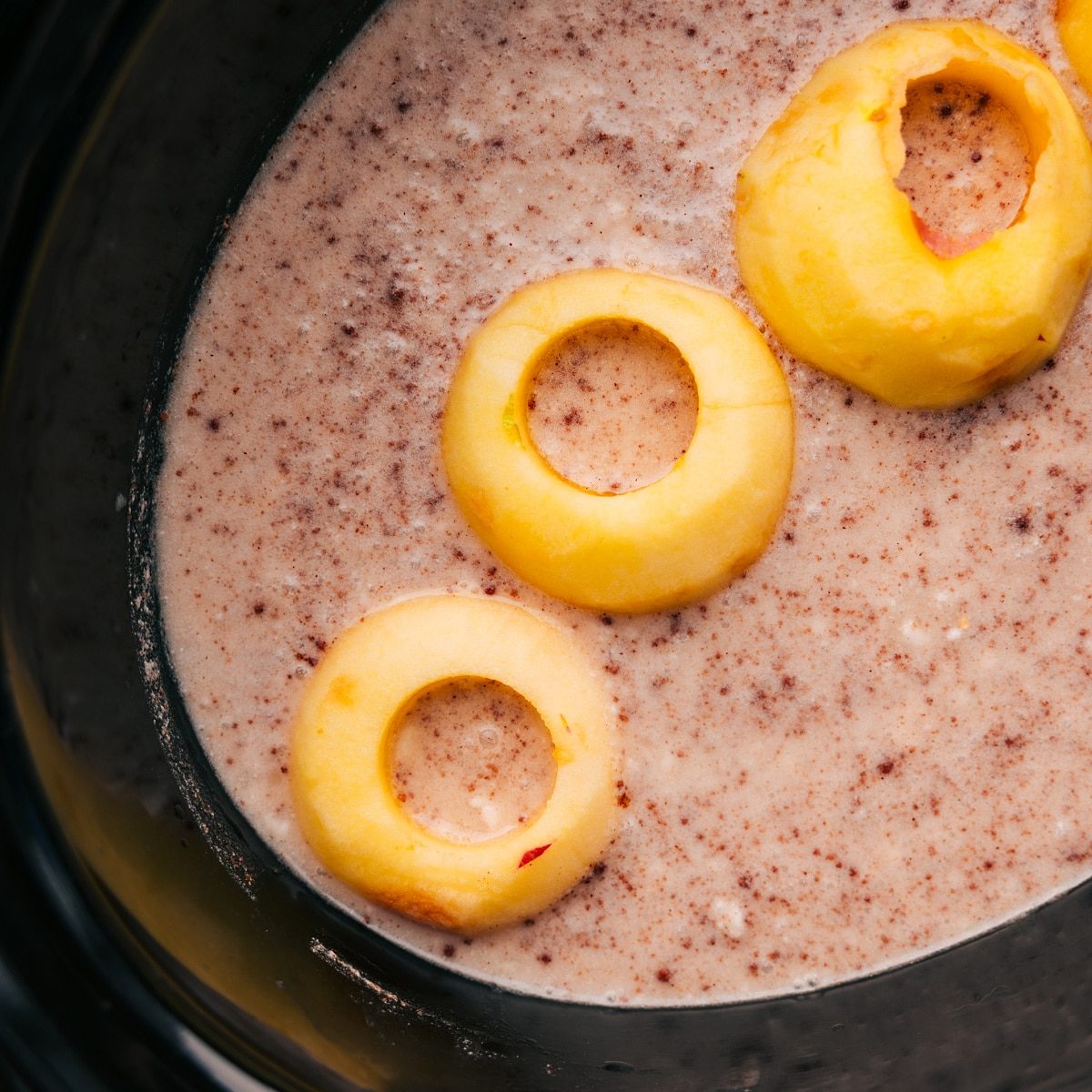 Chopped apples being added to the slow cooker for this Overnight Steel Cut Oats Recipe.