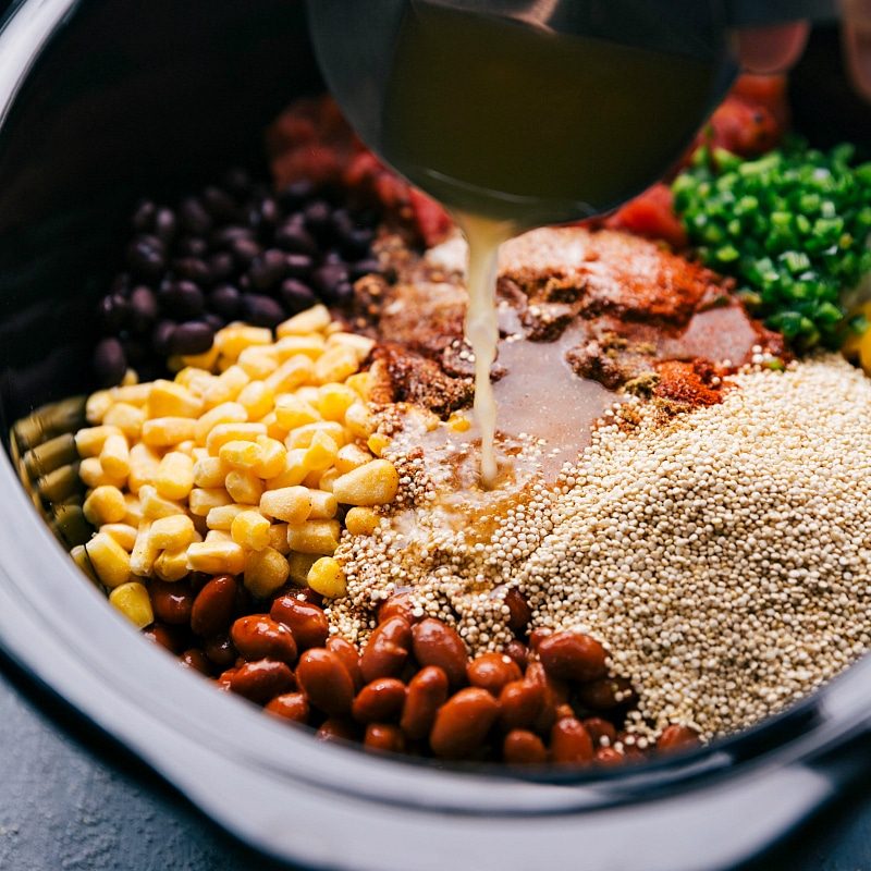 Adding vegetable stock to slow cooker Quinoa.